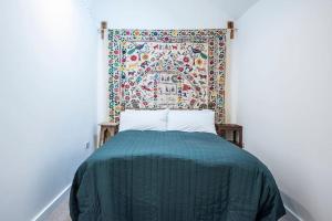 a bed in a room with a tapestry on the wall at Old Printing Press, Leiston in Leiston