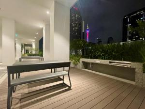 un banc sur une terrasse avec vue sur la ville dans l'établissement Quill Residence KLCC by Hausome, à Kuala Lumpur