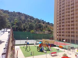 een speeltuin met een schommel in een gebouw bij Rincon de Loix Benidorm in Benidorm
