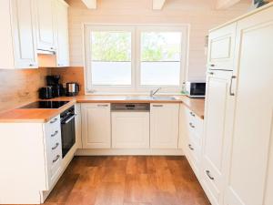 a kitchen with white cabinets and a window at Ferienhaus Ostseelodge in Schönberg