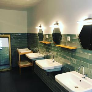 a bathroom with three sinks and two mirrors at Arkeo - Luxury tents and cabins at the river in Nonceveux