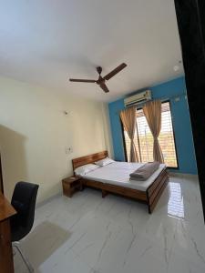 een slaapkamer met een bed en een plafondventilator bij La Residence in Navi Mumbai
