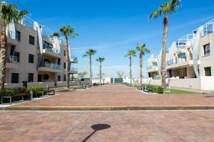 a street with palm trees in front of condos at Playa Elisa Bay app 411 in Pilar de la Horadada