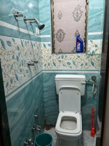 een kleine badkamer met een toilet en een spiegel bij La Residence in Navi Mumbai