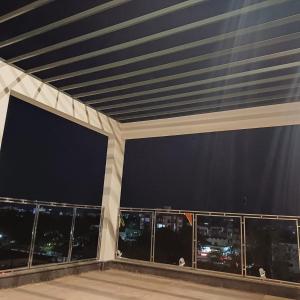 a balcony with a view of the city at night at Hotel Taj Akash in Deoghar