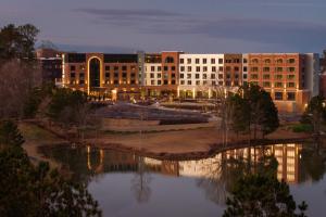 a large building with a lake in front of it at Trilith Guesthouse, Fayetteville, GA, a Tribute Portfolio Hotel in Fayetteville