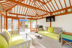 蓝梦岛Villa Vie Lembongan的客厅里有一张绿色的沙发和一张桌子