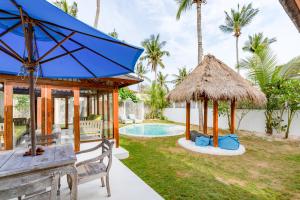 蓝梦岛Villa Vie Lembongan的别墅 - 带游泳池和蓝伞