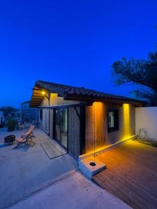 uma casa com um deque de madeira com luzes em Gökler Çiftliğinde Ekolojik Tatil em Foça