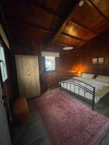 a bedroom with a bed and a window and a rug at Gökler Çiftliğinde Ekolojik Tatil in Foça