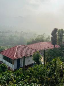 una casa con un tetto rosso su una collina di Coorg Heritage Hill View Resort a Madikeri