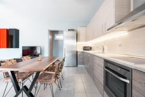 a kitchen with a long wooden table and chairs at Villa MATA - 600m² with Private Pool and Jacuzzi in Kalithies