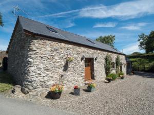 a stone building with potted plants in front of it at Eirlys Llanrhystud in Llanrhystyd