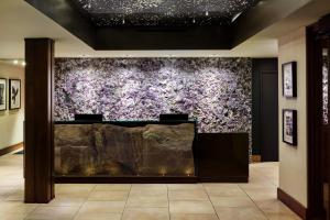 Sky Rock Sedona, a Tribute Portfolio Hotel في سيدونا: جدار في غرفة مع الزهور الأرجوانية