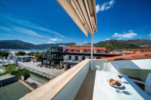 a balcony with a table with a bowl of fruit on it at Dedeminn Garden House in Göcek