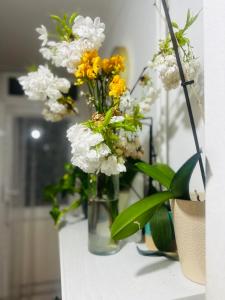 a vase filled with white and yellow flowers on a table at Brockmer House in London