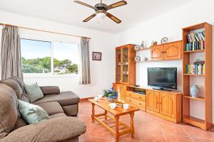 uma sala de estar com um sofá e uma televisão em Villa Toymi by Villa Plus em Cala Blanca