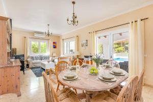 a dining room and living room with a table and chairs at Villa Nero by Villa Plus in Son Parc