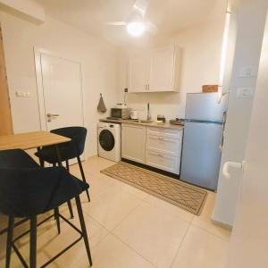 a kitchen with a refrigerator and a table and chairs at apartments with separate kitchen by the sea in Ashdod