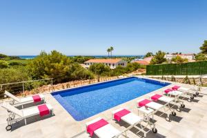 a villa with a swimming pool and lounge chairs at Villa Dolce Vita by Villa Plus in Alaior