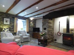 a living room with a red couch and a fireplace at Ty Cam Abercych in Abercych