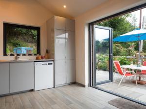 a kitchen with sliding glass doors and a table with an umbrella at Ty Cam Abercych in Abercych