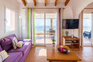 Villa Camamilla by Villa Plus في الايور: غرفة معيشة مع أريكة أرجوانية وإطلالة على المحيط