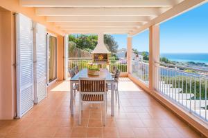 a balcony with a table and chairs and a view of the ocean at Villa Camamilla by Villa Plus in Alaior