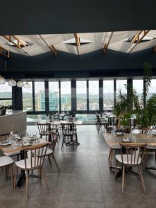 a restaurant with tables and chairs and windows at Luxe Menlyn Oasis in Pretoria