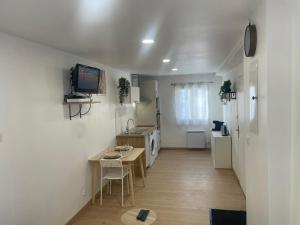 a kitchen with a small table and a kitchen with white appliances at Résidence Chene- 15 MN de Paris et 05 MN d'Orly Aéroport in Viry-Châtillon