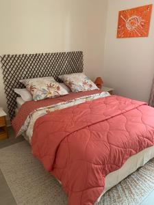 a bed with a red comforter in a bedroom at Le gîte entre val et rose in Provins