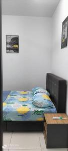 um quarto com uma cama com almofadas e uma mesa em Hana Homestay The Heights Residence em Ayer Keroh