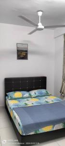 a bed with a black headboard and pillows on it at Hana Homestay The Heights Residence in Ayer Keroh