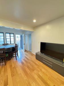 sala de estar con TV de pantalla plana grande en Cozy House, en Monterey Park