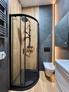 a shower with a glass door in a bathroom at Ocean Black jacuzzi in Kraków