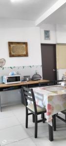 a kitchen with a table and a desk with a microwave at Hana Homestay The Heights Residence in Ayer Keroh