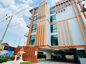 a building with an orange and white facade at MAHIDOL CONDO มหิดลคอนโด in Chiang Mai