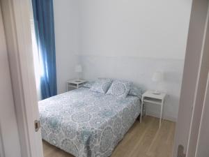 a bedroom with a bed with a blue and white comforter at Bon Repos 2 in Torroella de Montgrí +15 photos