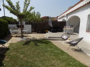 a backyard with chairs and a table and a tree at Bon Repos 2 in Torroella de Montgrí