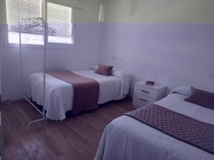 um quarto com 2 camas e uma janela em Casa Rural Maestros em Albanchez de Úbeda