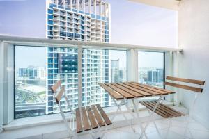 uma varanda com uma mesa e 2 cadeiras e uma grande janela em Studio Apartment in DAMAC Maison Prive Business Bay - High Floor em Dubai