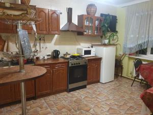 a kitchen with wooden cabinets and a stove top oven at Navigator in Chernivtsi