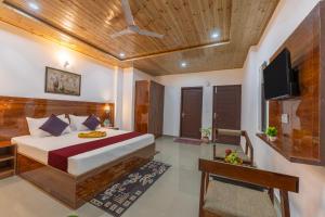 a bedroom with a bed and a flat screen tv at Sunset Vibes! By Western Stays Near Mall Road Kasauli in Kasauli