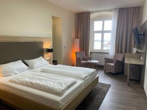 a hotel room with a large bed and chairs at Flair Hotel zum Schiff in Meersburg +105 photos