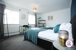 a bedroom with a bed and a table with a lamp at Milestone House, Large Modern House, Free Parking in Cardiff
