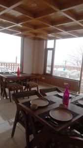 uma sala de jantar com mesas, cadeiras e janelas em MATSYA MANALI em Palchān