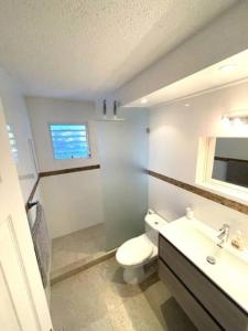 a bathroom with a toilet and a sink at New* Tropical Modern Townhouse in SXM in Simpson Bay
