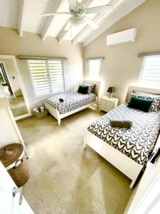a bedroom with two beds and a ceiling at New* Tropical Modern Townhouse in SXM in Simpson Bay