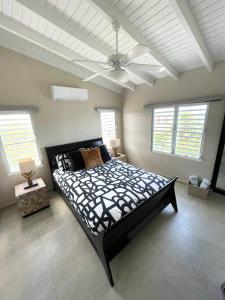 a bedroom with a large bed and a ceiling fan at New* Tropical Modern Townhouse in SXM in Simpson Bay