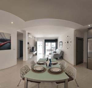 a living room with a table and chairs and a clock at Playa Elisa Bay app 411 in Pilar de la Horadada